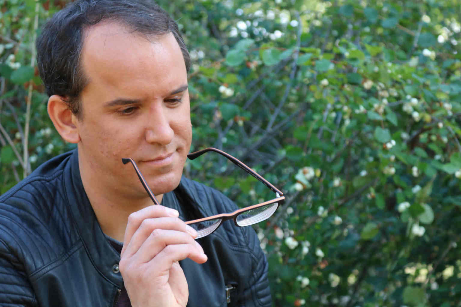 Ferdinand Saalbach hat seine Brille abgenommen, hält sie in der Hand und schaut sie an